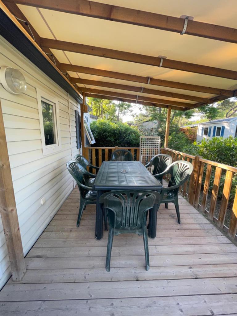 un patio avec une table et des chaises sur une terrasse dans l'établissement Mobil-Home au pied du Luberon, à La Roque-dʼAnthéron 11 autres photos