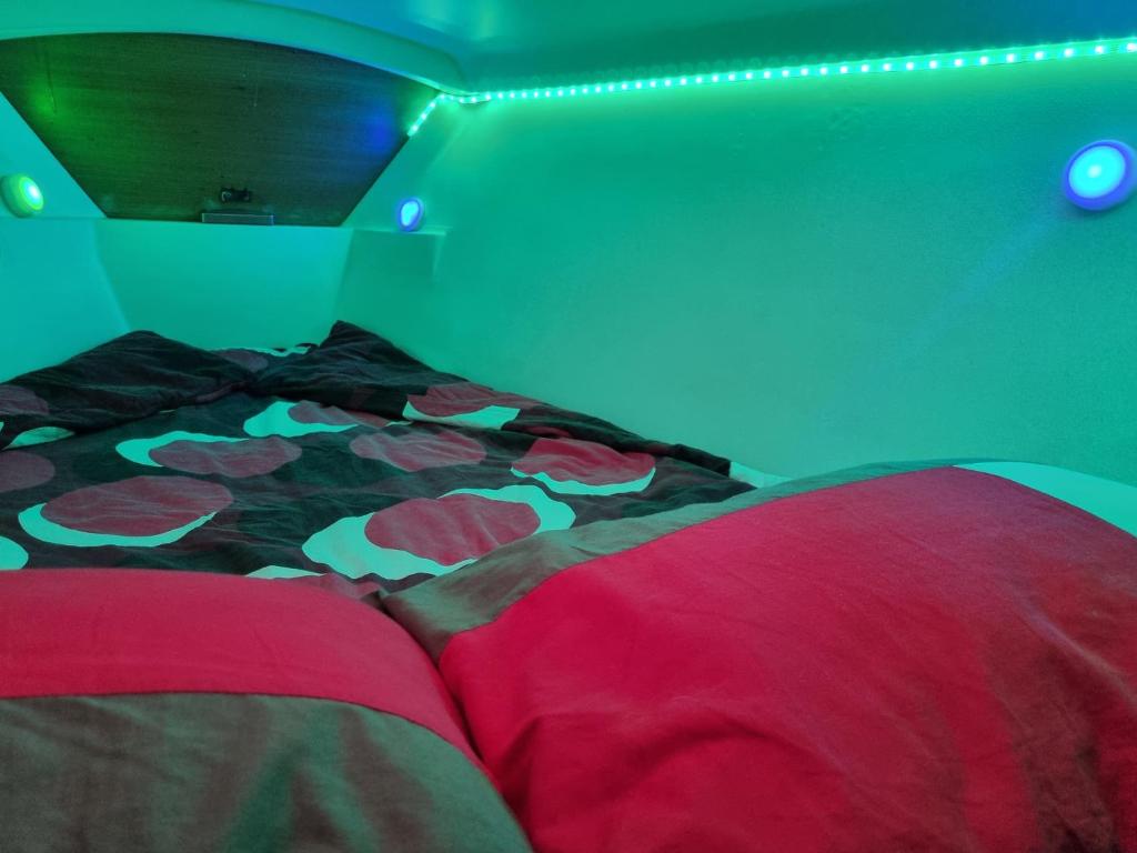 un lit avec une couette colorée dans une chambre dans l'établissement VOILIER AU SOLEIL LEVANT, au Havre