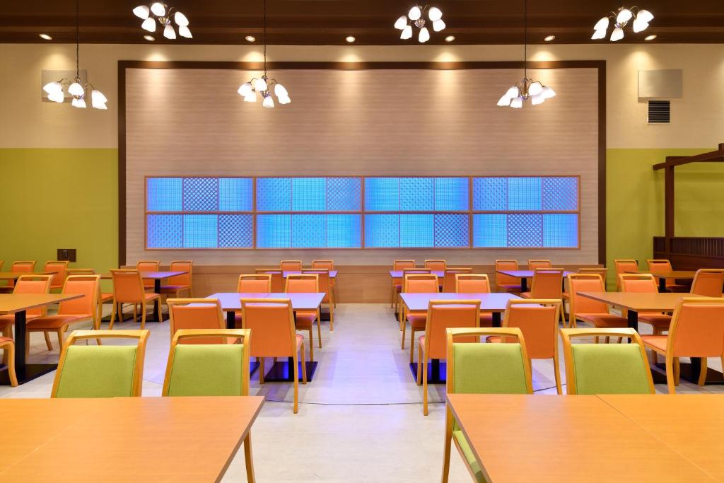 une salle à manger vide avec des tables et des chaises dans l'établissement Hotel Sunshine Kinugawa, à Nikkō 37 autres photos