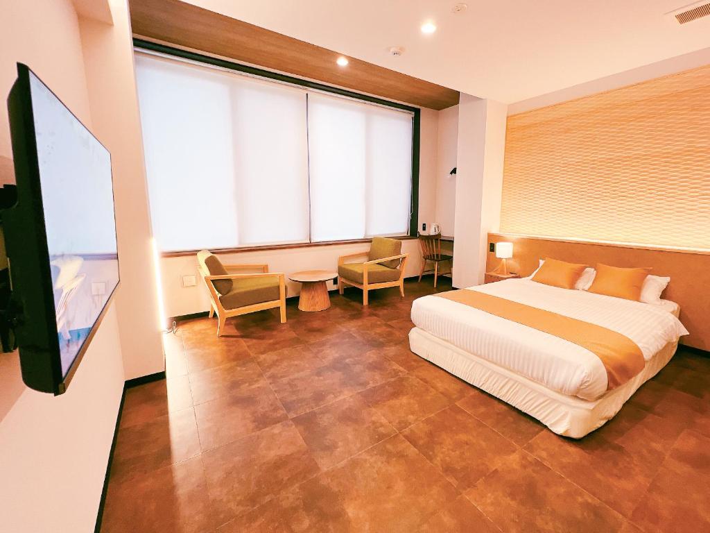 une chambre avec un lit et une grande fenêtre dans l'établissement FELIZ ARIFUKU ONSEN, à Gotsu