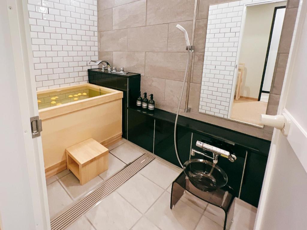 une salle de bain avec une baignoire, un lavabo et une douche dans l'établissement FELIZ ARIFUKU ONSEN, à Gotsu