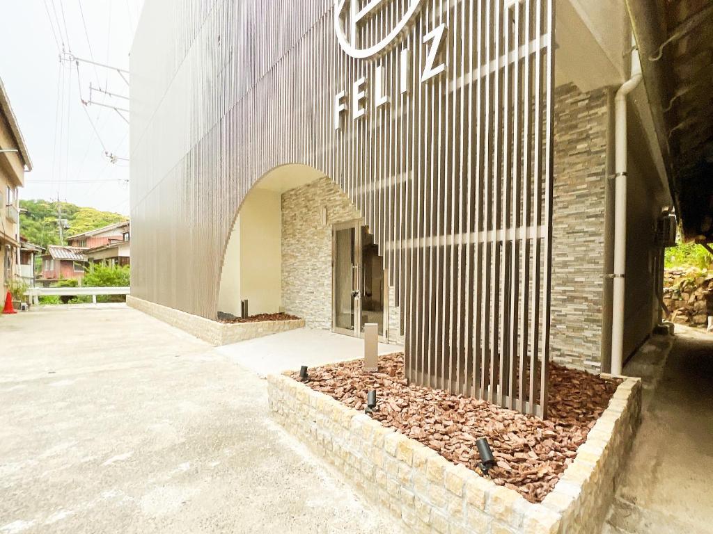 une entrée à un bâtiment avec un panneau sur celui-ci dans l'établissement FELIZ ARIFUKU ONSEN, à Gotsu