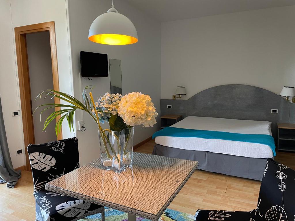 un salon avec un vase de fleurs sur une table dans l'établissement Residence Alexandra Stay, à Sirmione 94 autres photos