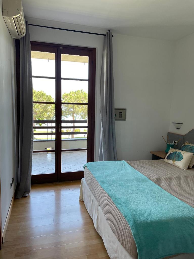 une chambre avec un lit et une porte coulissante en verre dans l'établissement Residence Alexandra Stay, à Sirmione