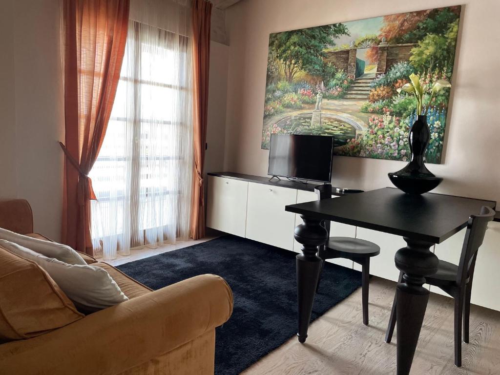 un salon avec une table et une télévision dans l'établissement Residence Alexandra Stay, à Sirmione