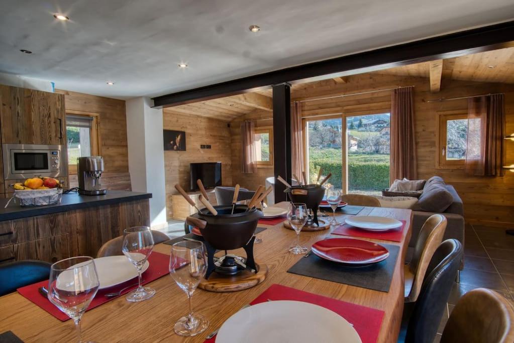 une salle à manger avec une table et des verres à vin dans l'établissement chalet l'Orignal 145m2, 10pers, pied de piste,SPA, à Notre-Dame-de-Bellecombe