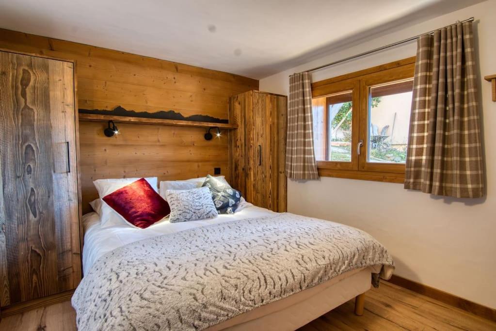 une chambre avec un lit avec des murs en bois et une fenêtre dans l'établissement chalet l'Orignal 145m2, 10pers, pied de piste,SPA, à Notre-Dame-de-Bellecombe