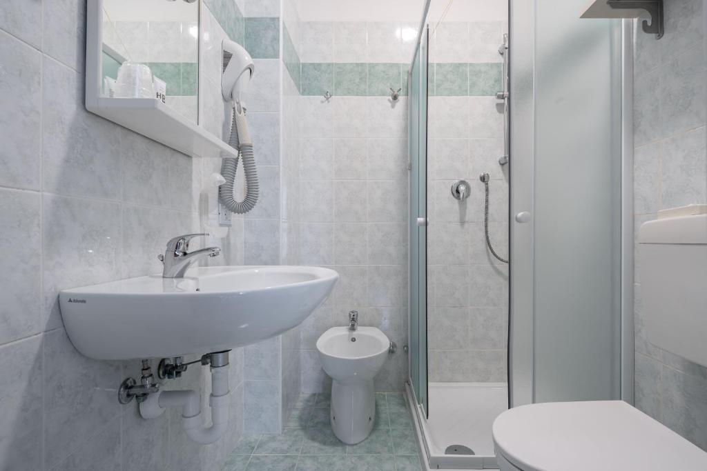 une salle de bain avec un lavabo, des toilettes et une douche dans l'établissement Hotel Boston 3 Stelle Superior Frontemare, à Lido di Jesolo