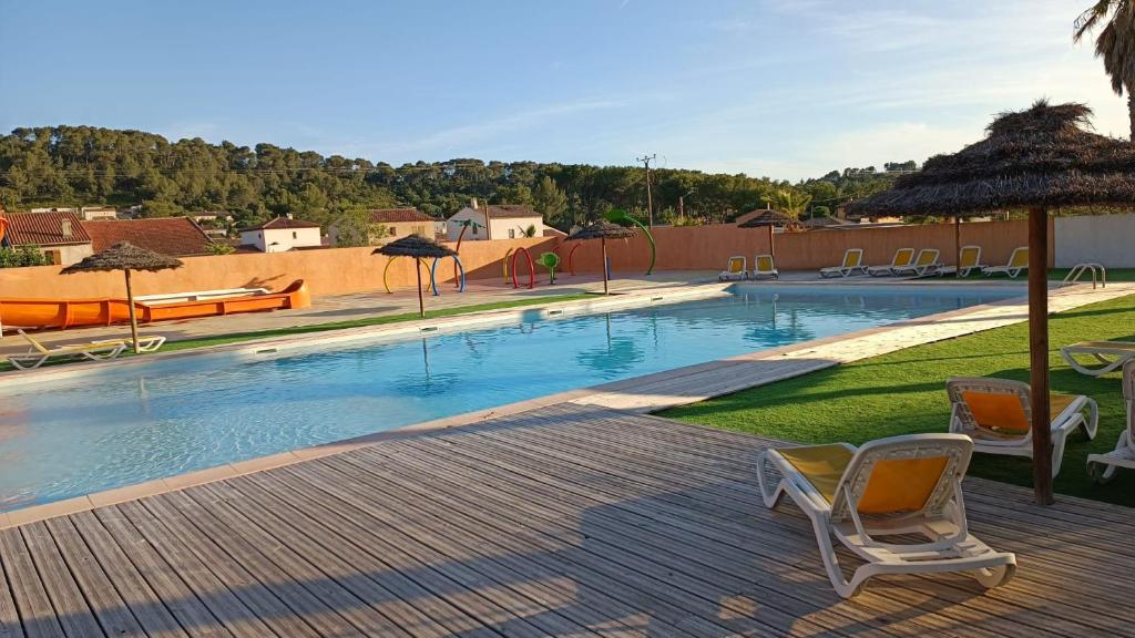 - une piscine avec une chaise et un parasol dans l'établissement LUXUEUX MOBIL-HOME, à Pierrefeu-du-Var 19 autres photos