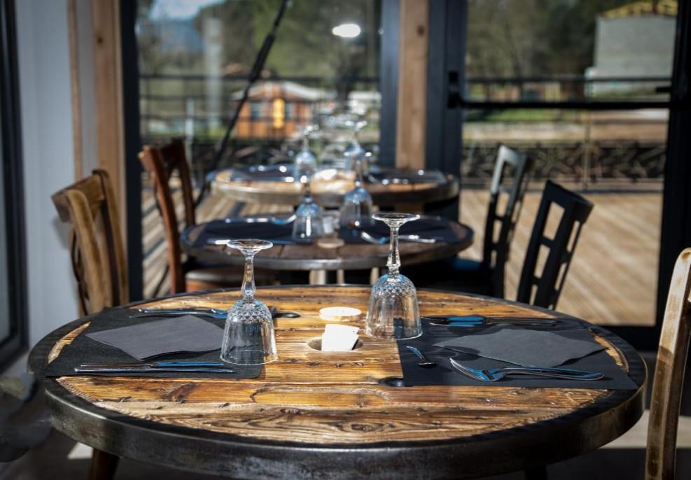 une rangée de tables en bois avec des verres à vin dessus dans l'établissement LUXUEUX MOBIL-HOME, à Pierrefeu-du-Var