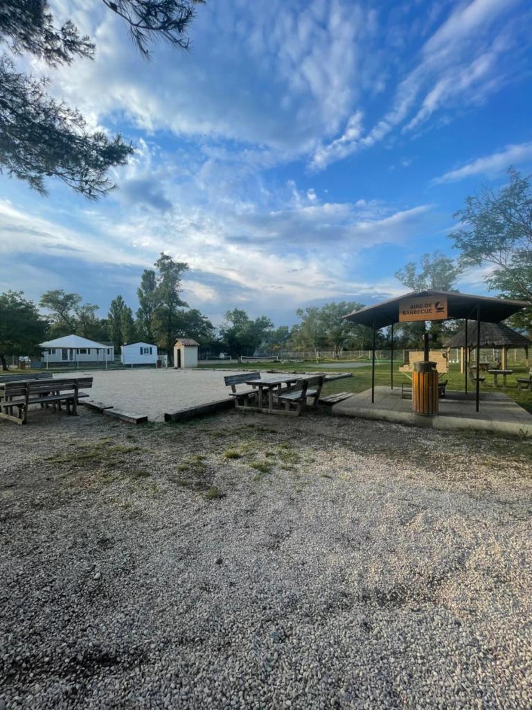 une aire de pique-nique avec deux tables de pique-nique et un parasol dans l'établissement Mobil-Home au pied du Luberon, à La Roque-dʼAnthéron