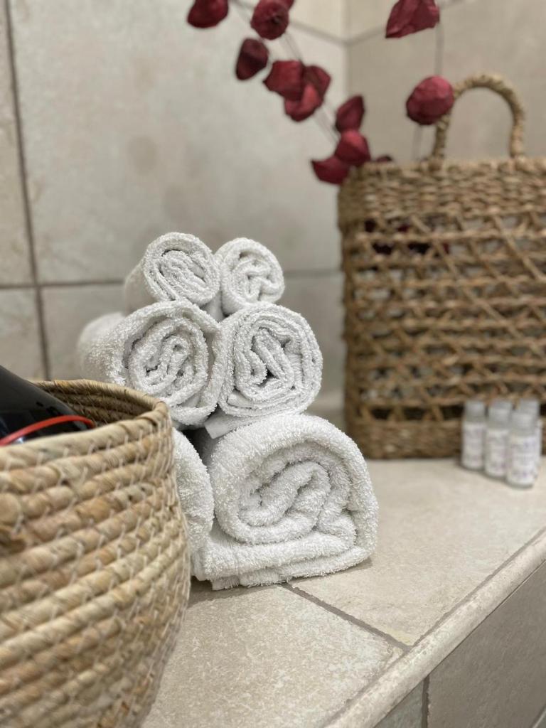 une pile de serviettes sur un comptoir dans une salle de bain dans l'établissement Maioliche Apartment, à Margherita di Savoia