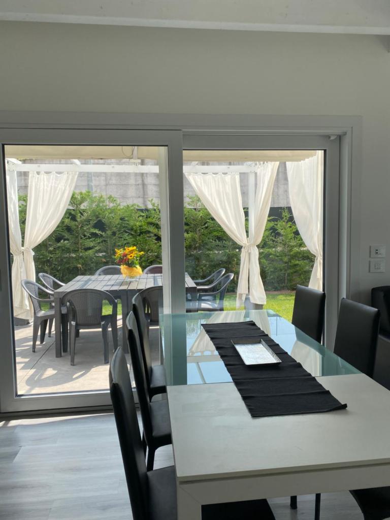 une salle à manger avec une table et des chaises et une grande fenêtre dans l'établissement Villa Carlotta, à Salionze