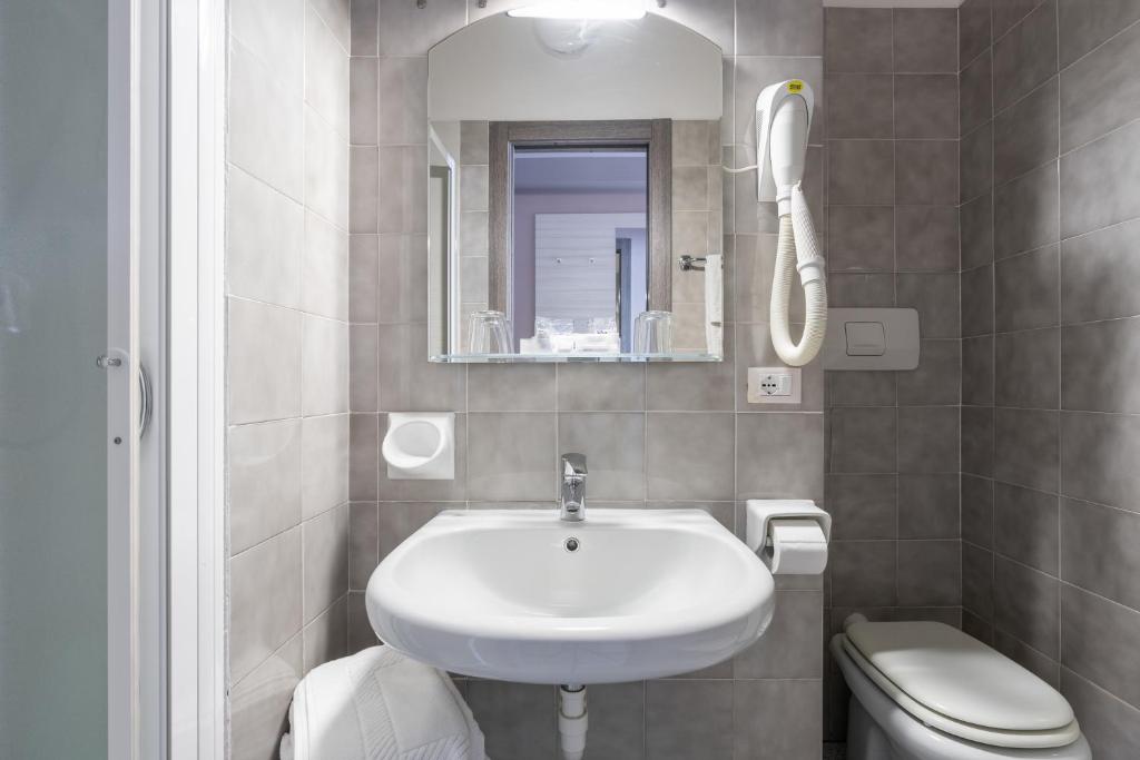 une salle de bain avec un lavabo blanc et des toilettes dans l'établissement Hotel Danio Lungomare, à Alassio
