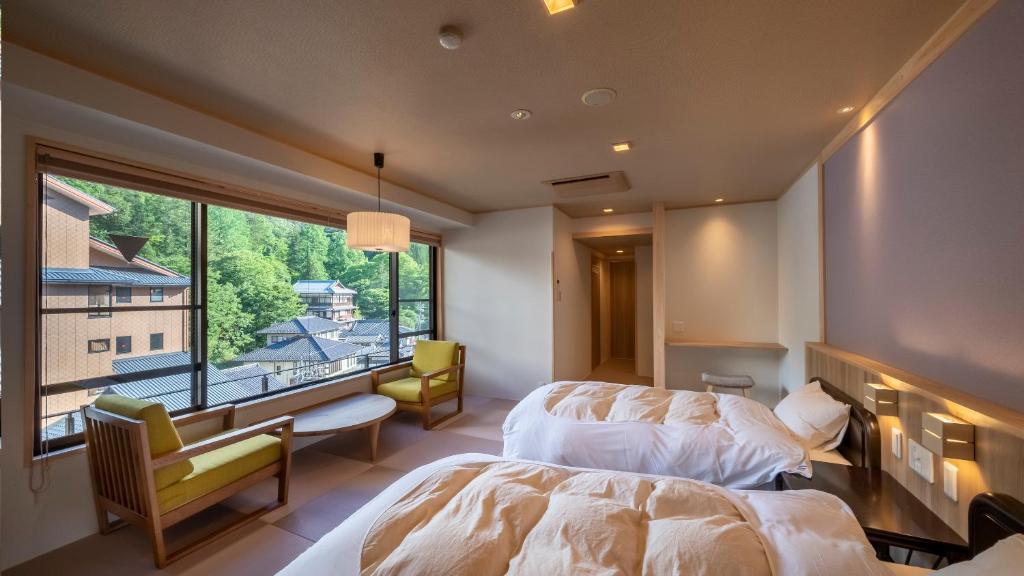 une chambre avec un lit et une grande fenêtre dans l'établissement Nakamatsuya Ryokan, à Ueda