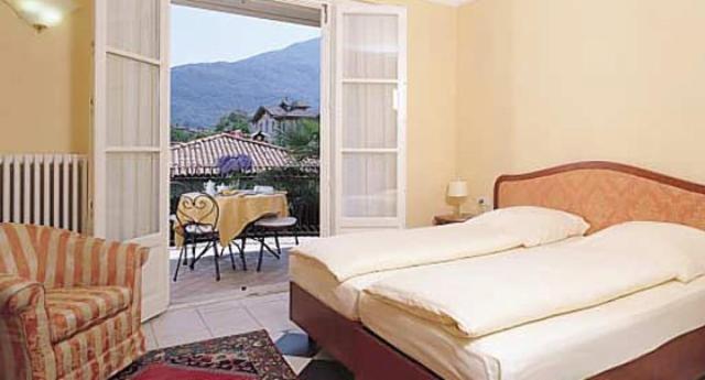 une chambre avec un lit et un balcon avec une table dans l'établissement Hotel Villa Delle Palme, à Cannobio 47 autres photos