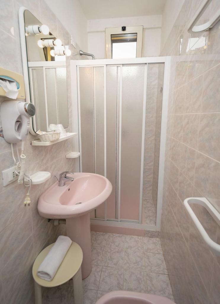 La salle de bains est pourvue d'un lavabo rose et d'une douche. dans l'établissement Hotel Anna, à Fetovaia 103 autres photos
