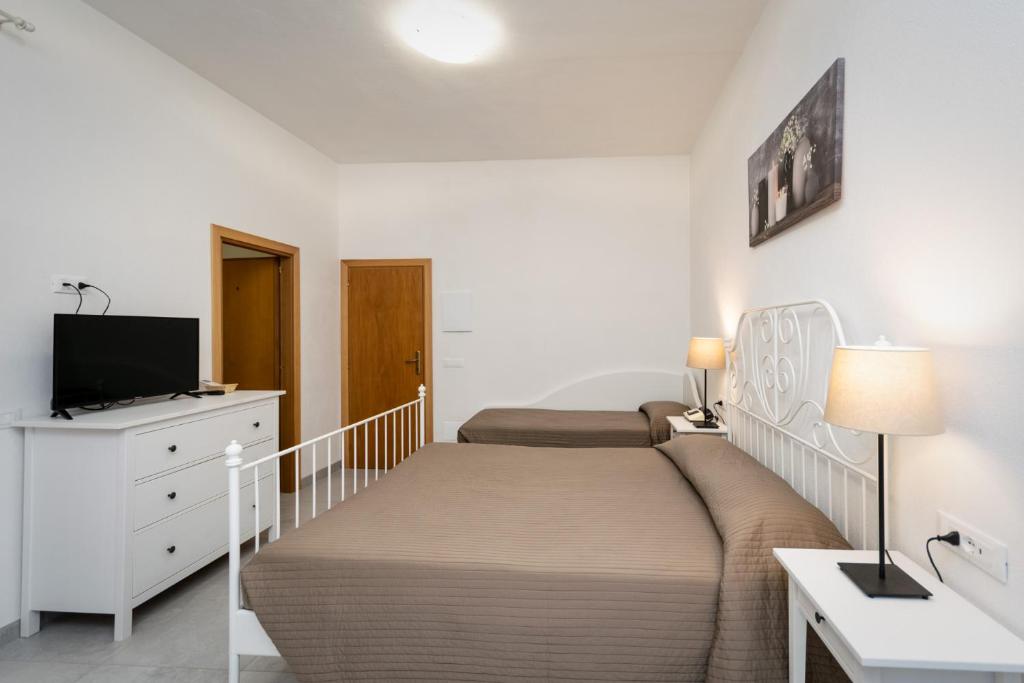 une chambre avec deux lits et une télévision à écran plat dans l'établissement Hotel Anna, à Fetovaia