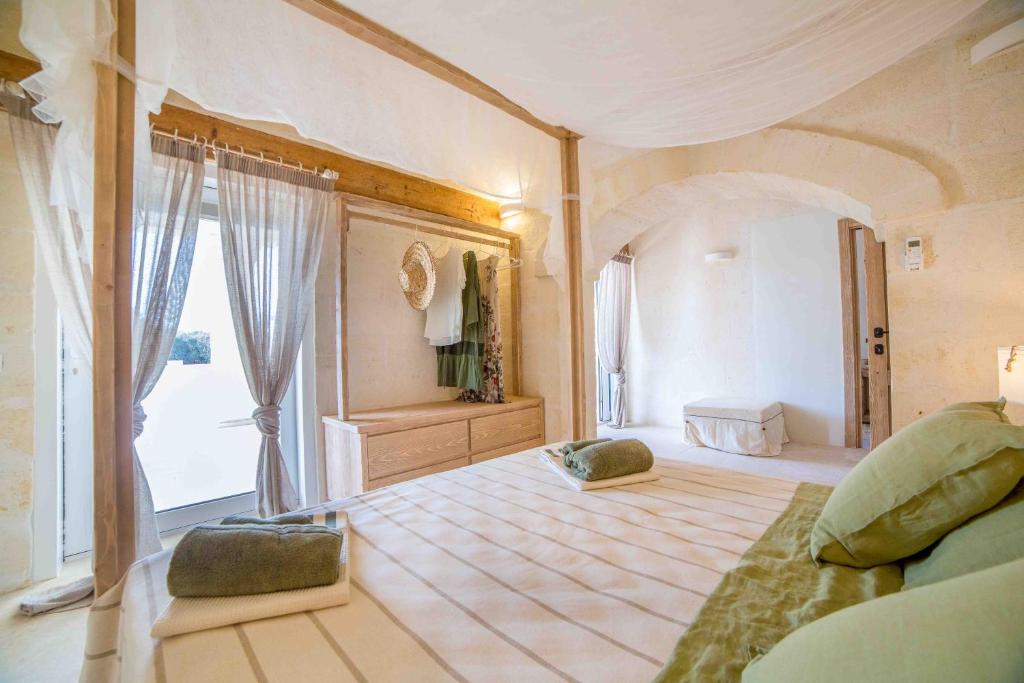 - une grande chambre avec un grand lit et une fenêtre dans l'établissement Antica Pietra - Villa con piscina in Puglia, à Ostuni 32 autres photos