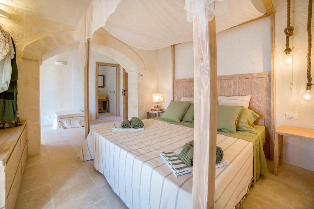 une chambre avec un grand lit dans une pièce dans l'établissement Antica Pietra - Villa con piscina in Puglia, à Ostuni