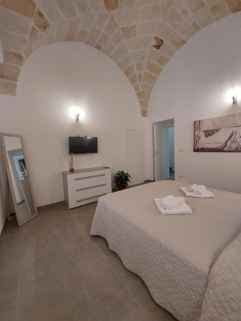 - une chambre avec un grand lit et une télévision dans l'établissement Tropical Palm Villa, à Monopoli 75 autres photos