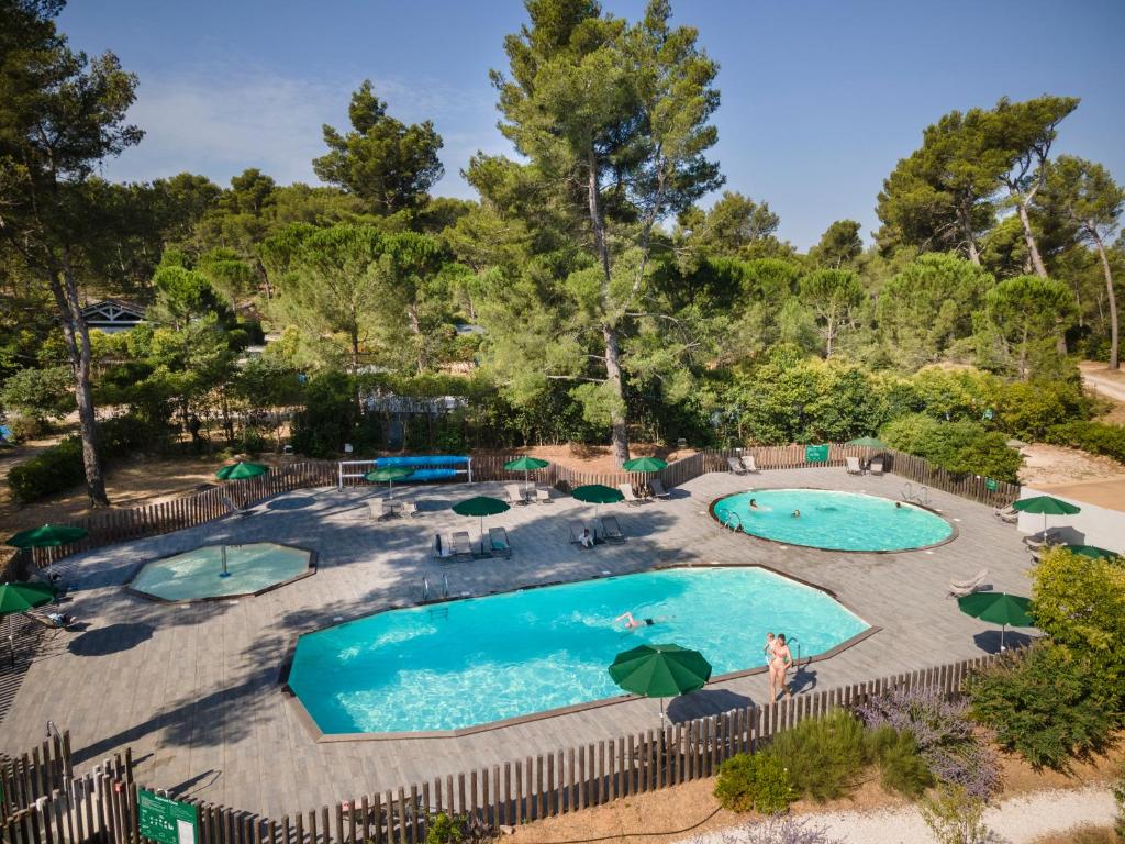 une vue aérienne d'une piscine avec des parasols dans l'établissement Huttopia Fontvieille, à Fontvieille