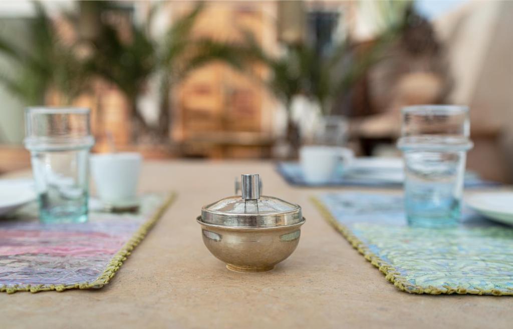 une table avec un bol sur une table avec des verres dans l'établissement Riad Al Massarah, à Marrakech