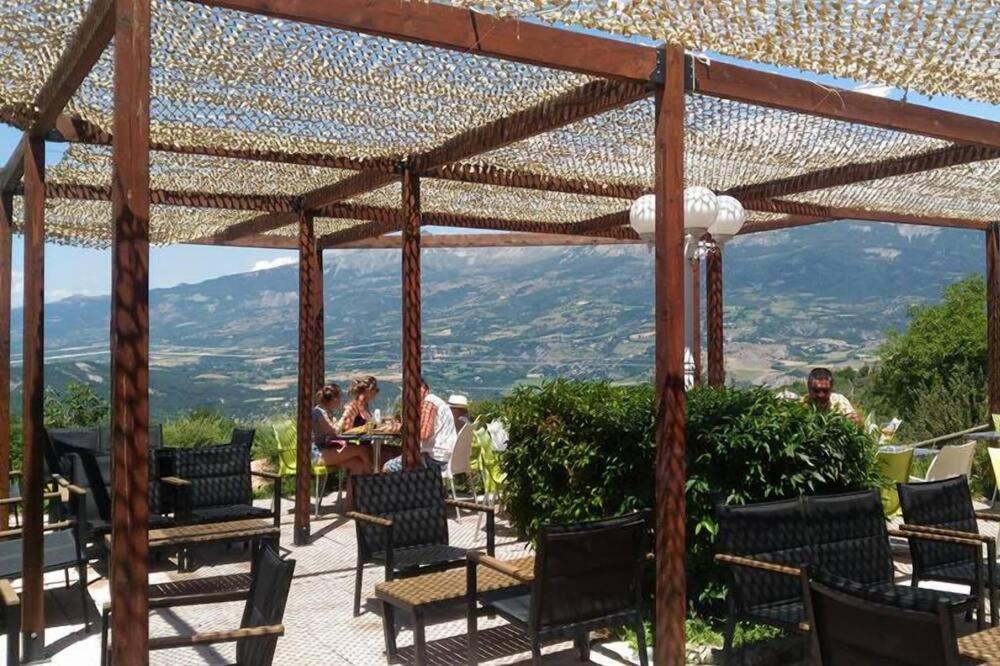 une pergola en bois avec des chaises et une vue sur les montagnes. dans l'établissement La Palatriere, à Le Sauze-du-lac