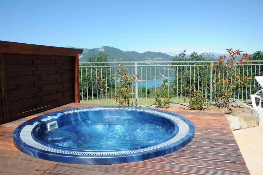 une grande baignoire bleue assise sur une terrasse en bois dans l'établissement La Palatriere, à Le Sauze-du-lac