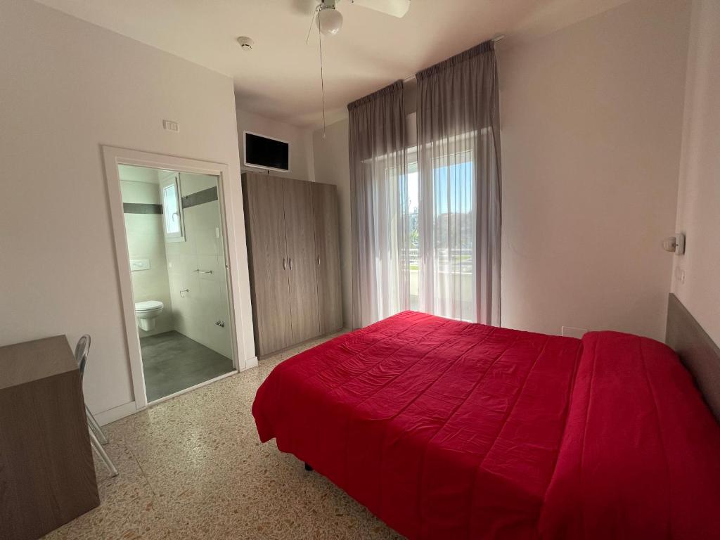 une chambre avec un lit rouge et une grande fenêtre dans l'établissement Hotel Sorriso, à Misano Adriatico 39 autres photos