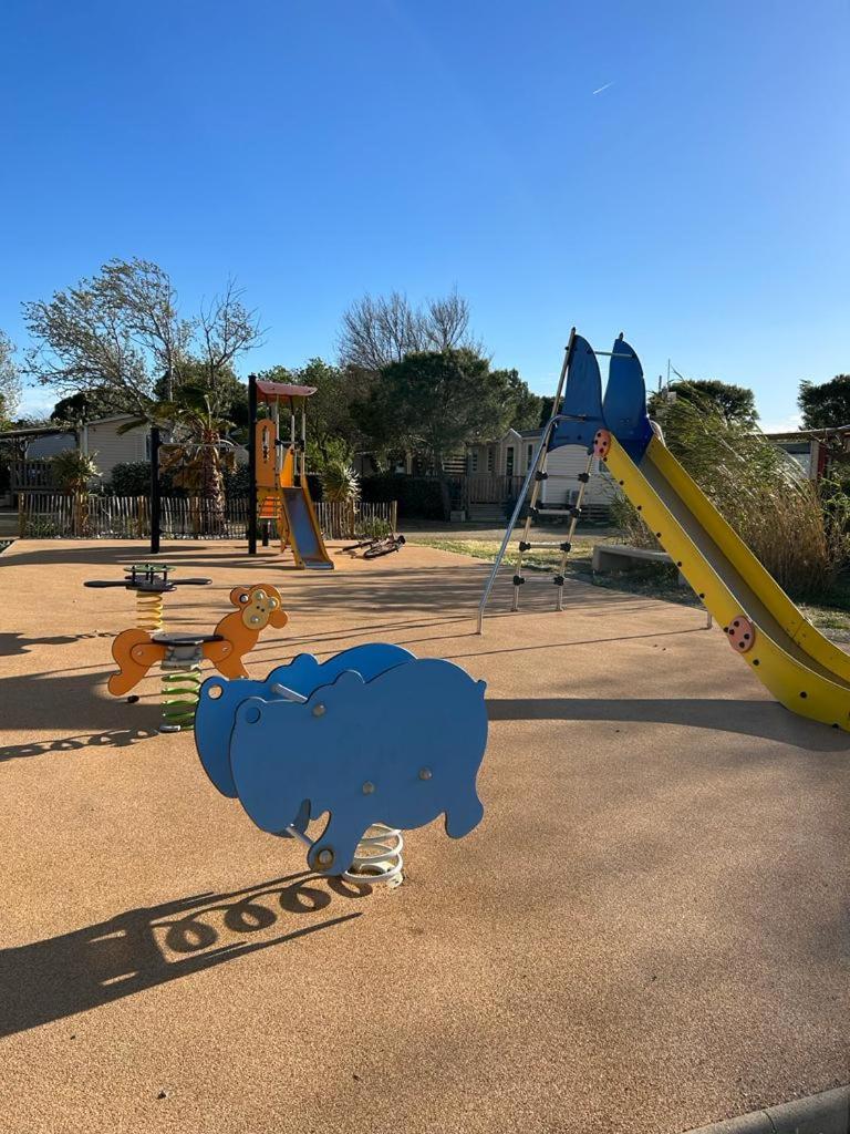 une aire de jeux avec un ours bleu et un toboggan dans l'établissement Mobil Home de Marine, à Port-la-Nouvelle