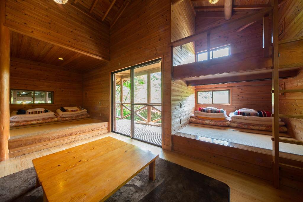une pièce vide avec un banc dans une cabane en rondins dans l'établissement Hiyoshi Forest Resort Yamanoie, à Nantan city