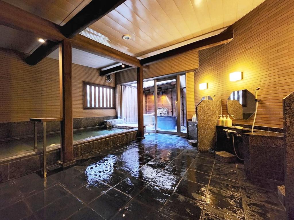 une salle de bain avec une baignoire et un lavabo dans une pièce dans l'établissement Ryokan Tanabe 旅館 田邊, à Takayama