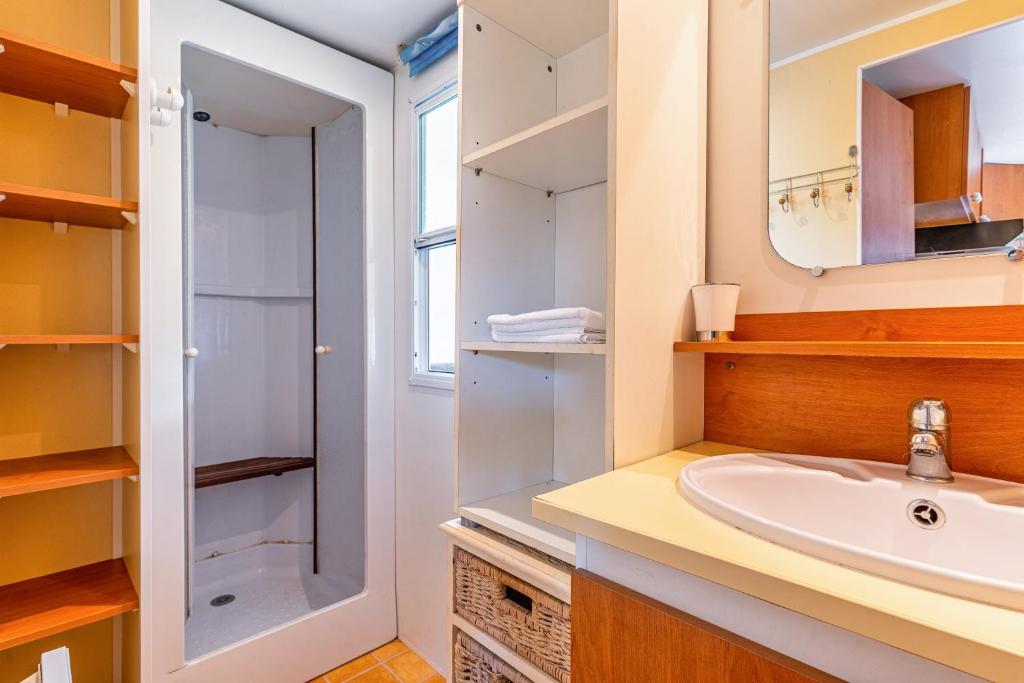 une salle de bain avec un lavabo et une douche dans l'établissement Mobilhome bord de mer Gujan Mestras, à Gujan-Mestras 19 autres photos