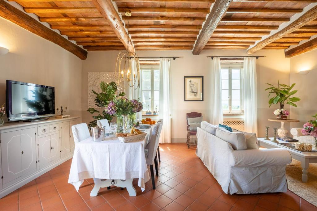 un salon avec une table et des chaises dans l'établissement Fattoria Camigliano, Luxury Farmhouse with Pool inside a Wine Estate, à Capannori