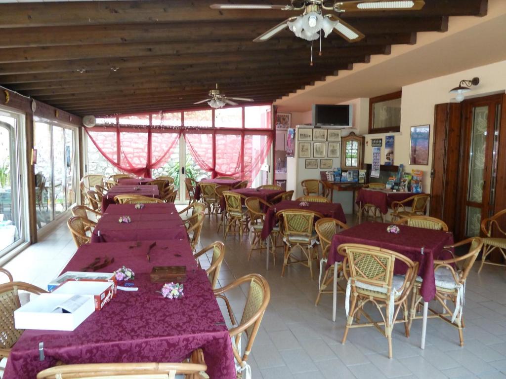 un restaurant avec tables et chaises et nappes violettes dans l'établissement Albergo Casa Este, à Brenzone