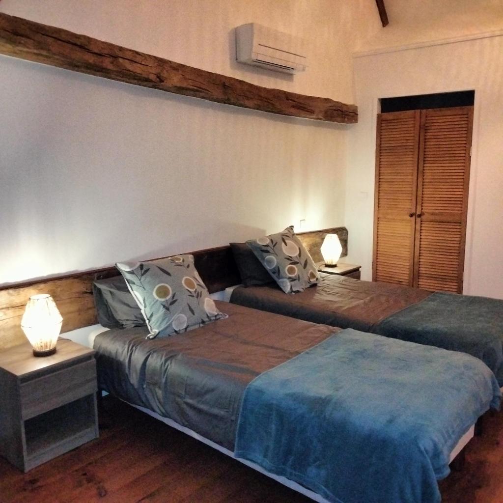 deux lits dans une chambre avec deux lampes dans l'établissement Domaine Hourcabis - 2 gîtes 4 et 6 personnes, à Montestrucq
