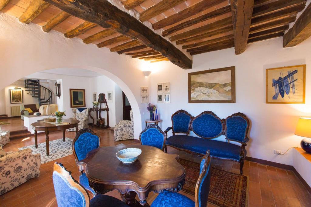 un salon avec une table et des chaises bleues dans l'établissement Villa Giorgia, à San Gimignano