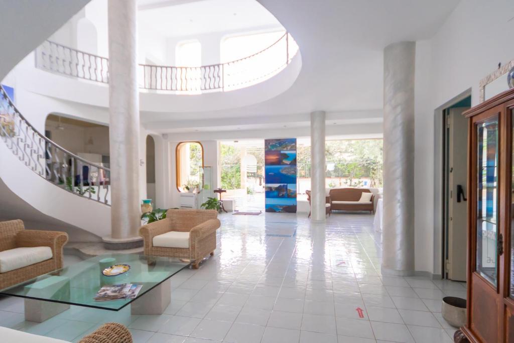 un salon avec un escalier et une table en verre dans l'établissement Hotel America, à Marina di Camerota