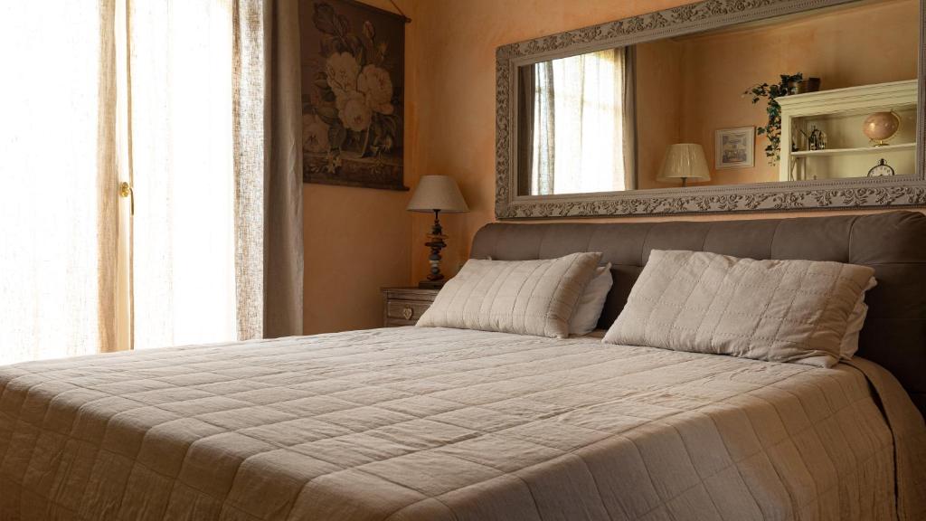 une chambre avec un grand lit avec un miroir au mur dans l'établissement Garda Resort Village I Borghi, à Peschiera del Garda 38 autres photos