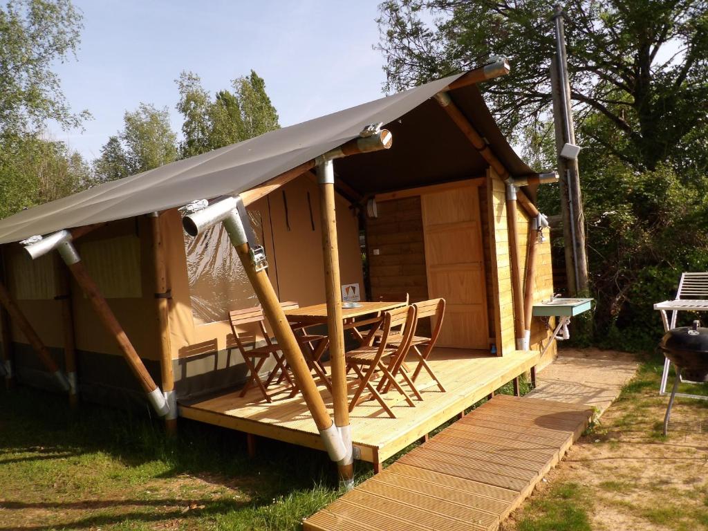 une cabine avec une table et des chaises sur une terrasse dans l'établissement Camping Smile & Braudieres, à Mézières-sous-Lavardin