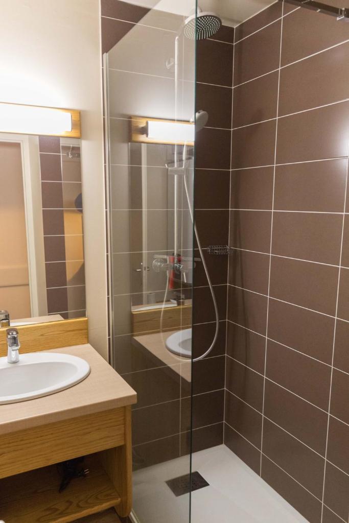 une salle de bain avec douche et lavabo dans l'établissement Studio Lou Kiwi - Résidence Bec de l Aigle, à Le Lioran