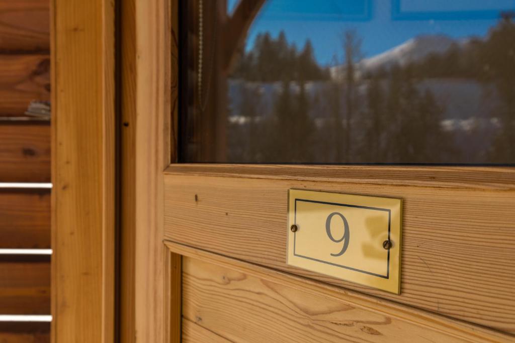 une porte en bois avec son numéro dans l'établissement Studio Lou Kiwi - Résidence Bec de l Aigle, à Le Lioran