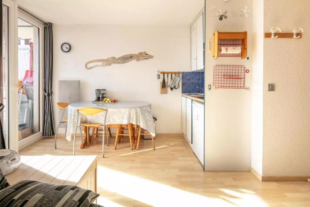 une cuisine et une salle à manger avec une table et des chaises dans l'établissement Séjour Grand Ski, à Huez