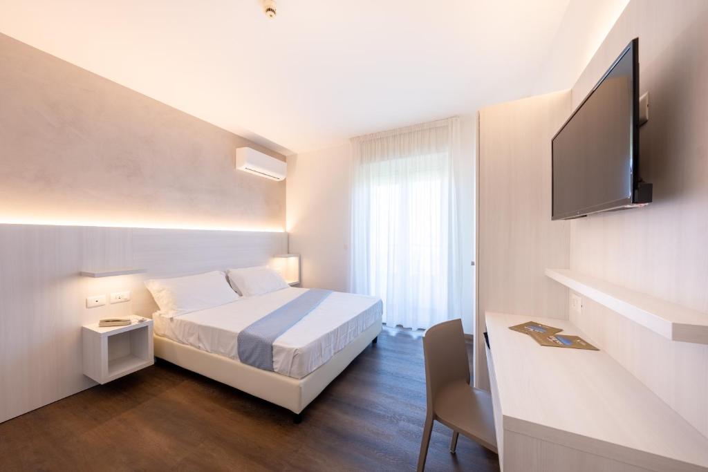 une chambre d'hôtel avec un lit et une télévision à écran plat dans l'établissement Hotel Corfù, à Pineto