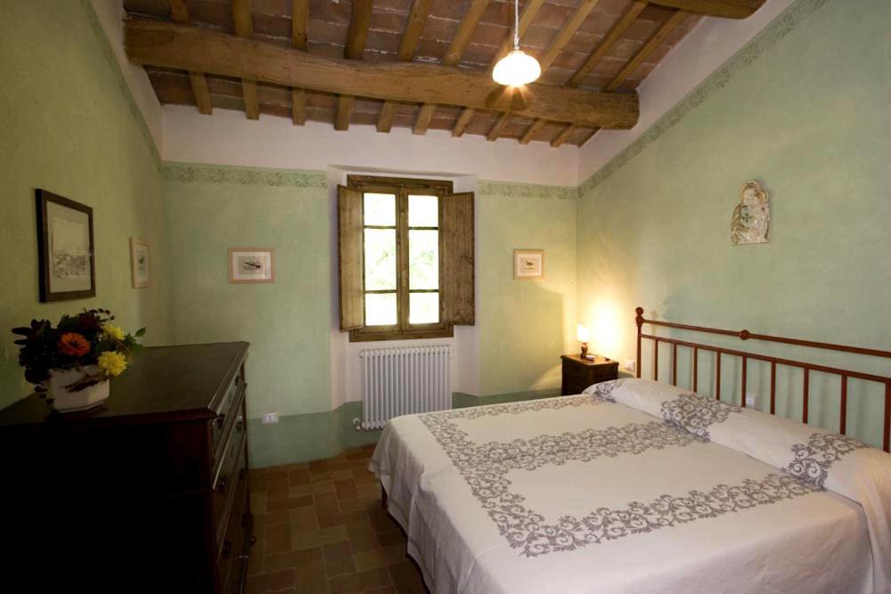 une chambre avec un grand lit et une fenêtre dans l'établissement Villa Il Cigno, à Brisighella