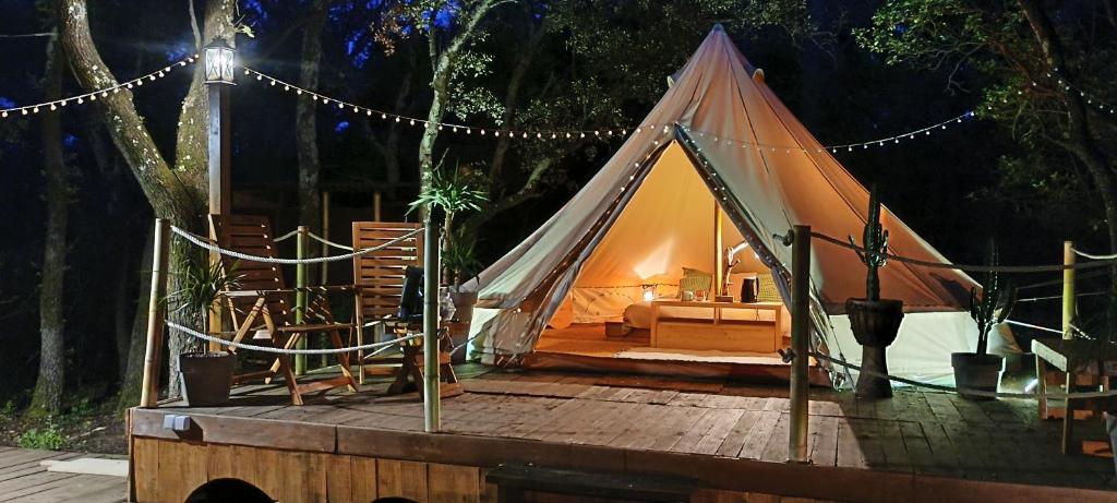 une tente posée sur une terrasse en bois avec des lumières dans l'établissement Évasion en pleine nature, Tipi insolite et Jacuzzi au Pont du Gard !, à Vers-Pont-du-Gard
