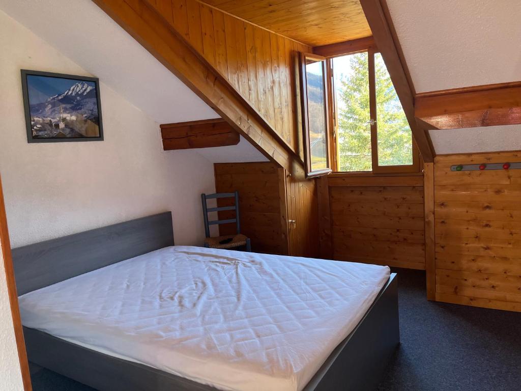 une chambre avec un lit dans une pièce avec des fenêtres dans l'établissement L’écureuil St Léger Les Mélèzes, à Saint-Léger-les-Mélèzes