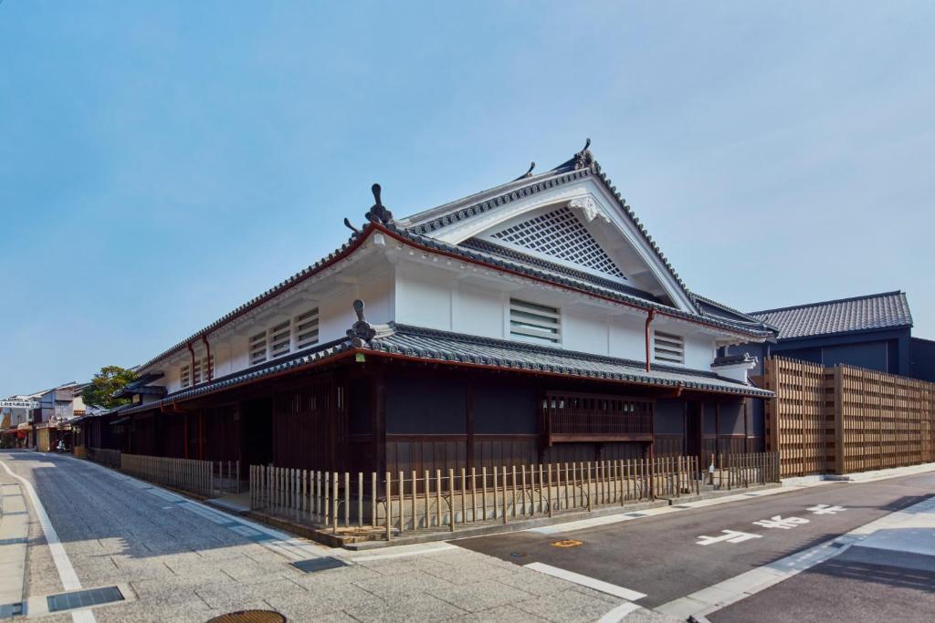 un bâtiment avec un toit asiatique dans une rue dans l'établissement Azumi Setoda, à Onomichi