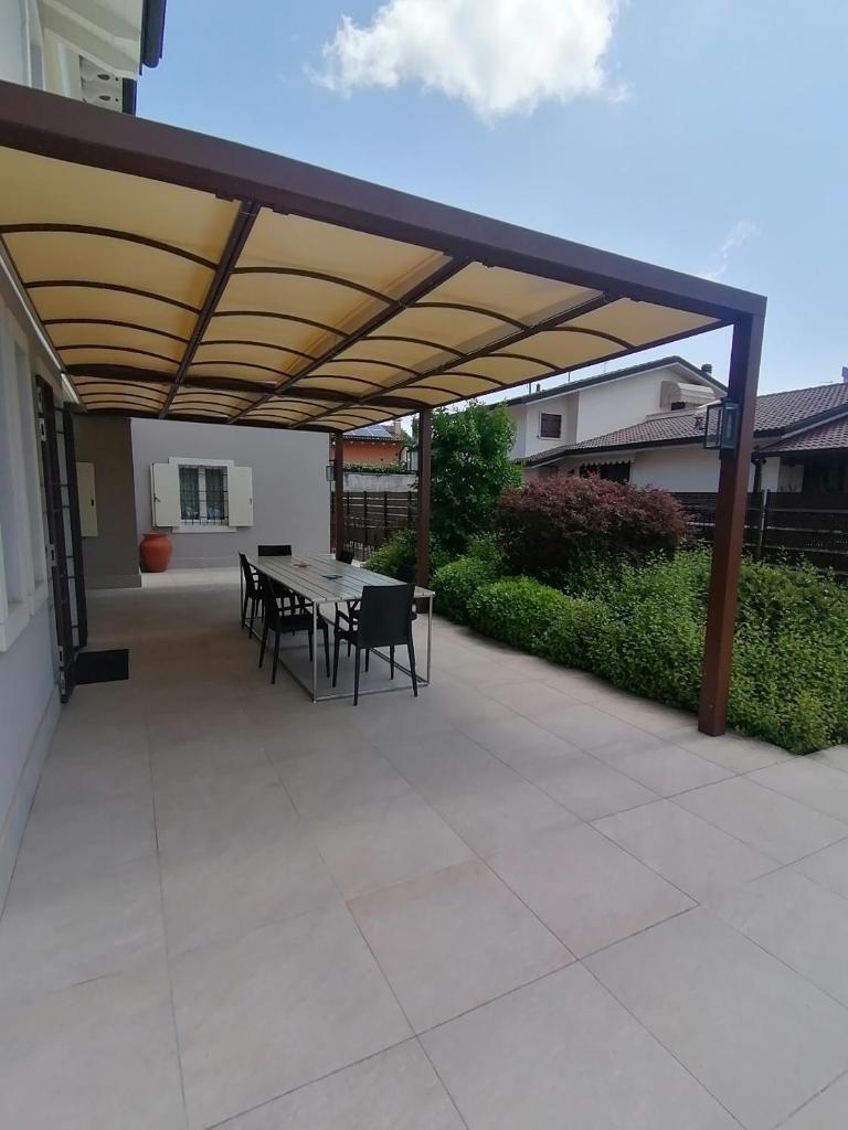 d'une terrasse avec une table et des chaises sous un auvent. dans l'établissement Villa Zarina - ZAvillas - up to 12 people, à Peschiera del Garda